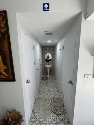 a hallway with a bathroom with a sink and a toilet at First Villa Life Hostel in Bangkok