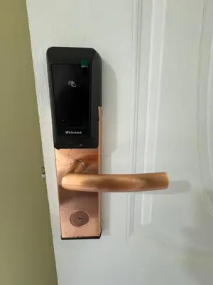 a wooden door latch with a monitor on it at First Villa Life Hostel in Bangkok
