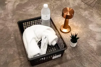 a basket with a white animal and a bottle of water at The 63rd Hostel in Bangkok