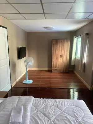 a bedroom with a bed and a room with a fan at 93 House in Ban Bang Toei (1)