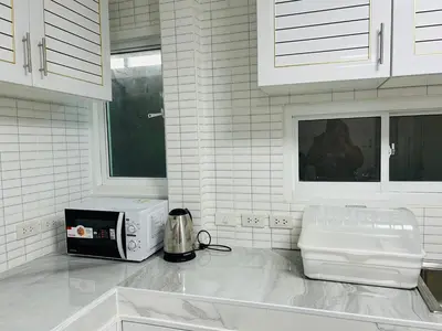 a kitchen with a counter top with a microwave at 93 House in Ban Bang Toei (1)