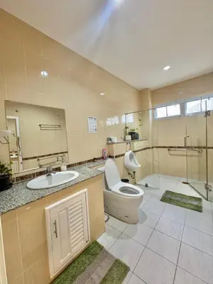 a bathroom with a toilet and a sink and a shower at Baan Farang in Bangkok