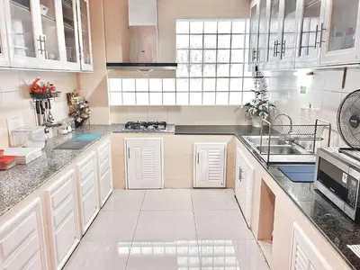 a large white kitchen with white cabinets and appliances at Baan Farang in Bangkok