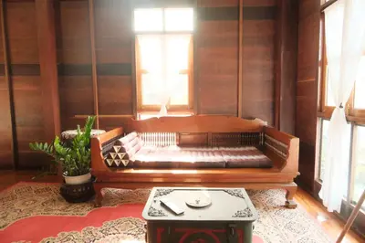 a bench in a room with a table and windows at Bannai Bangkoknoi บ้านในบางกอกน้อย in Ban Bang Bamru