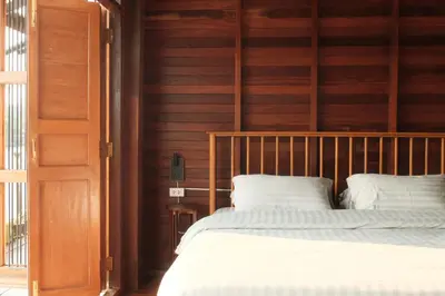 a bedroom with a bed and a wooden wall at Bannai Bangkoknoi บ้านในบางกอกน้อย in Ban Bang Bamru