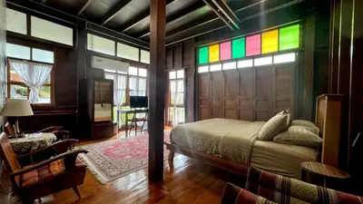 a bedroom with a bed and a rainbow stained glass window at Bannai Bangkoknoi บ้านในบางกอกน้อย in Ban Bang Bamru