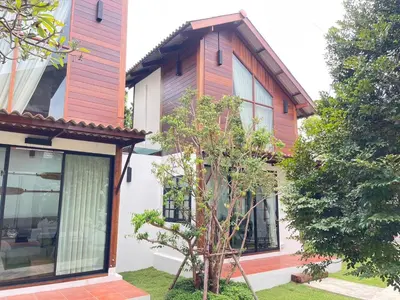 a small tree in front of a house at Baanrongmai Canal Front Homestay in Bang Chak
