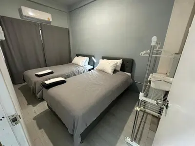 a room with two beds and a glass door at Bee House 172 only 300m to BTS Talat Phlu in Bangkok
