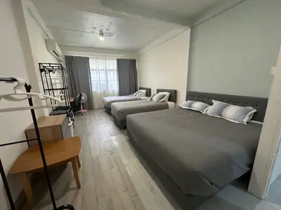 a bedroom with two beds and a table and a desk at Bee House 172 only 300m to BTS Talat Phlu in Bangkok