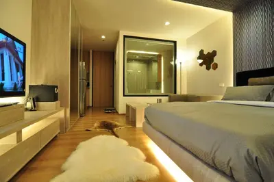 a bedroom with a bed and a cat laying on the floor at 1 Bedroom near MRT & BTS station. in Bangkok