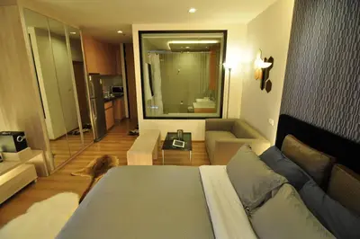 a bedroom with a bed and a couch and a mirror at 1 Bedroom near MRT & BTS station. in Bangkok