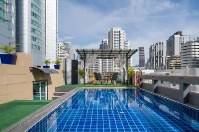 a swimming pool on top of a building with a city at Aspira Suites Sukhumvit 20 in Bangkok
