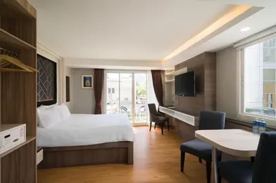 a hotel room with a bed and a desk at Aspira Suites Sukhumvit 20 in Bangkok