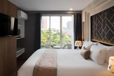 a bedroom with a large bed and a large window at Aspira Suites Sukhumvit 20 in Bangkok