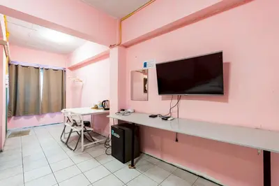 a room with a tv on a pink wall at xx GO INN The Grand Palace โกอินน์ MRT สามยอด in Bangkok