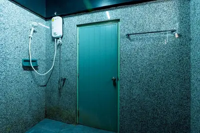 a shower stall with a green door in a bathroom at xx GO INN The Grand Palace โกอินน์ MRT สามยอด in Bangkok