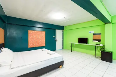 a bedroom with a bed and a green wall at xx GO INN The Grand Palace โกอินน์ MRT สามยอด in Bangkok