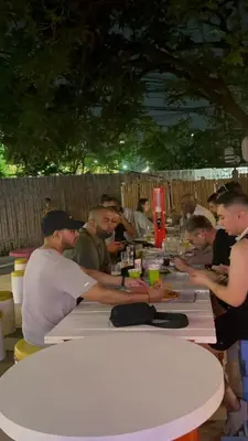 a group of people sitting at a table eating food at Revolution Khao San by The Bliss in Bangkok