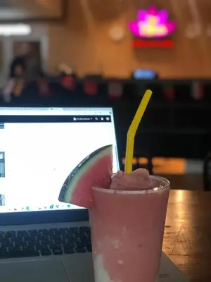 a drink sitting on a table next to a laptop at Revolution Khao San by The Bliss in Bangkok