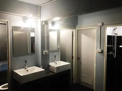 a bathroom with two sinks and two mirrors at Revolution Khao San by The Bliss in Bangkok
