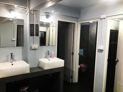 a bathroom with two sinks and a shower at Revolution Khao San by The Bliss in Bangkok