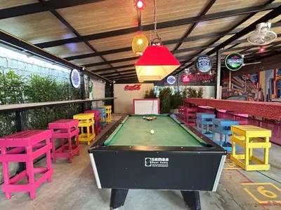 a pool table in a restaurant with colorful tables and chairs at Revolution Khao San by The Bliss in Bangkok