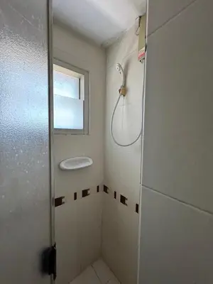 a bathroom with a shower with a window at Orchid Inn SKV3 in Bangkok