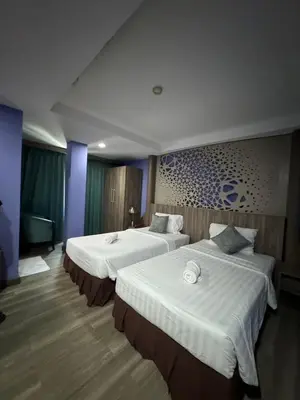 a hotel room with two beds with white sheets at Orchid Inn SKV3 in Bangkok