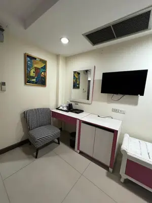 a room with a desk and a tv and a chair at Orchid Inn SKV3 in Bangkok