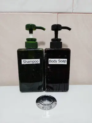 two bottles of shampoo and body soap sitting on a counter at 201-Olan Place Homely room Free Wi-Fi and Near BTS line in Bangkok