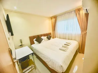 a small bedroom with a bed and a window at ABC HA Hotel Bangkok in Bangkok