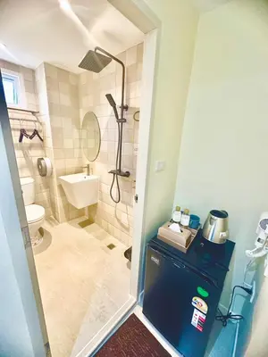 a small bathroom with a shower and a toilet at ABC HA Hotel Bangkok in Bangkok