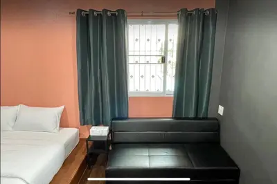 a bedroom with a bed and a window with green curtains at Purple House King BR Walk to Grand Palace in Bangkok