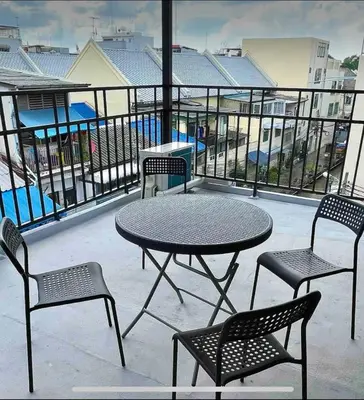 a table and chairs on a balcony with a table and chairs at Purple House King BR Walk to Grand Palace in Bangkok
