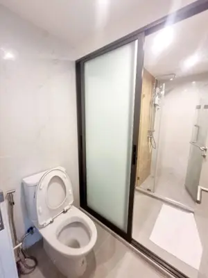 a bathroom with a white toilet and a shower at คอนโด 1 ห้องนอน ใกล้บีทีเอสอ่อนนุช สายสีเขียว ที่นอนKing Size วิวสระว่ายน้ำ in Amphoe Phra Khanong