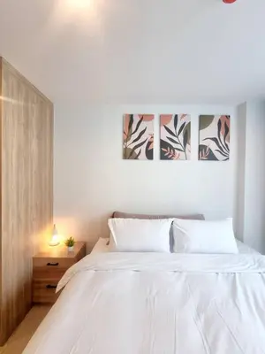 a bedroom with a white bed and a wooden cabinet at คอนโด 1 ห้องนอน ใกล้บีทีเอสอ่อนนุช สายสีเขียว ที่นอนKing Size วิวสระว่ายน้ำ in Amphoe Phra Khanong
