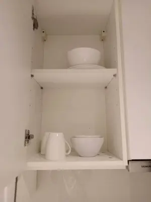 a white cabinet with bowls and plates on it at Circle S Sukhumvit12 NearBTS,MRT in Bang Kapi