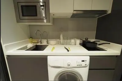 a kitchen with a sink and a stove and a dishwasher at Circle S Sukhumvit12 NearBTS,MRT in Bang Kapi