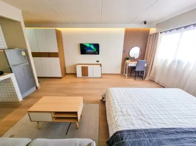 a room with two beds and a table and a kitchen at BetterRoom เมืองทองธานี C6 in Pak Kret