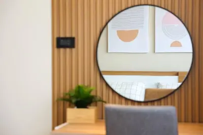 a mirror on a wall with a table and a chair at BetterRoom เมืองทองธานี C6 in Pak Kret