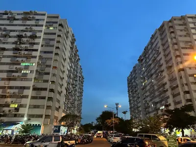 two tall buildings with cars parked in a parking lot at ห้องพักเมืองทองธานี Happiness Sleep P1 in Ban Song Hong