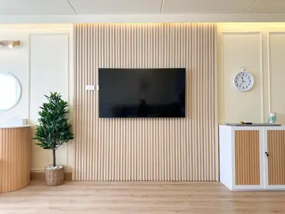 a living room with a television on a striped wall at ห้องพักเมืองทองธานี Happiness Sleep P1 in Ban Song Hong