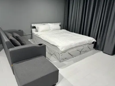 a bed and a chair in a room at Impact Donmuang Popular Condo C5 in Bangkok