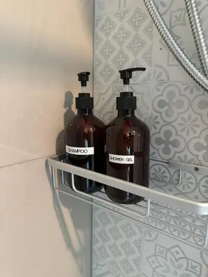 two bottles of soap sitting on a shelf in a bathroom at Rimm49 Bangkok in Bangkok