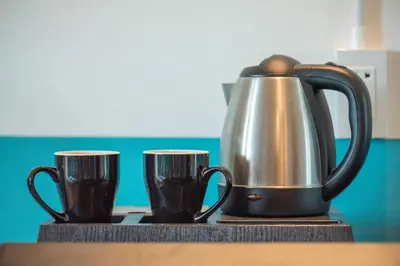 a tea kettle and two cups on a counter at SHIN Hotel Chinatown in Khlong San