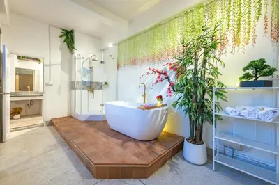 a bathroom with a large tub and a plant at SHIN Hotel Chinatown in Khlong San