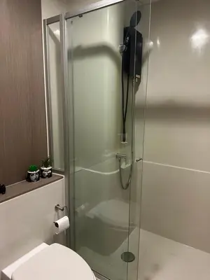 a bathroom with a glass shower with a toilet at Casa Bondia in Bangkok