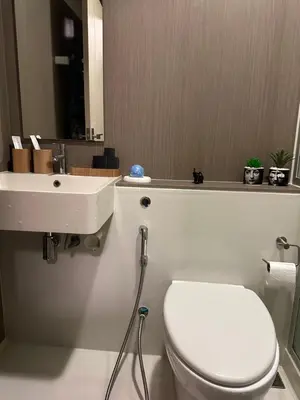 a bathroom with a white toilet and a sink at Casa Bondia in Bangkok