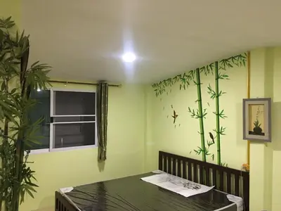 a dining room with a table and plants on the wall at GreenRoom Guest House Very Close Bangkok Hospital in Thailand in Bangkok