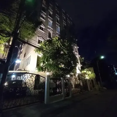 a building with a fence in front of it at night at Chezmoi Bangkok Sukhumvit 26 Private Executive Residence 444 in Khlong Toei